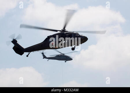 Zwei Texas National Guard UH-60 Blackhawk Hubschrauber zeigen einige der Funktionen für die Gäste, die sich für die diesjährige Texas Streitkräfte Open House und amerikanischen Helden Air Show im Camp Mabry, in Austin, Texas, April 26-27, 2014. Die Demonstration hier dargestellt ist der Rettungshubschrauber heben Ein verwundeter Soldat aus schädigt Weise. Texas Militär Zug in der Lage sein, jedem Staat, der Katastrophe Mission mit Funktionen, Luftfahrt, Sicherheit und transportieren sollte der Gouverneur rufen wir/sie gehören zu reagieren. Durch Personalsgt fotografiert. Timothy Pruitt, Texas State Guar Stockfoto