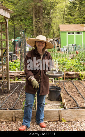 Weibliche Gärtner eine Pause vom pflanzen Samen im Frühling in einer gemeinschaft Garten in Issaquah, Washington, USA Stockfoto