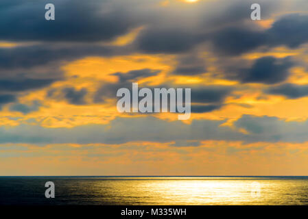 Stilisierte lange Belichtung Sonnenuntergang Meereslandschaft mit verschiedenen Schattierungen von rot, orange, gelb und blau. Stockfoto