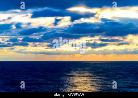 Stilisierte lange Belichtung Sonnenuntergang Meereslandschaft mit verschiedenen Schattierungen von rot, orange, gelb und blau. Stockfoto