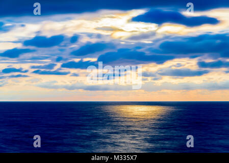 Stilisierte lange Belichtung Sonnenuntergang Meereslandschaft mit verschiedenen Schattierungen von rot, orange, gelb und blau. Stockfoto