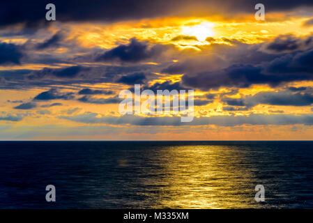 Stilisierte lange Belichtung Sonnenuntergang Meereslandschaft mit verschiedenen Schattierungen von rot, orange, gelb und blau. Stockfoto