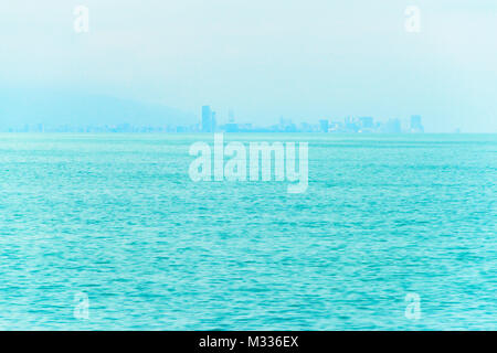 Angeln Boot im Vordergrund mit fogy Meer und die Skyline im Hintergrund. Stockfoto