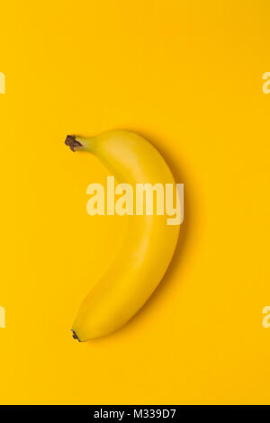 Single Frische, gelbe, reife Banane auf gelbem Hintergrund Stockfoto