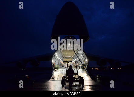 Ein US-Flieger vom 106 Rettung Flügel an der New York Air National Guard Positionen ein Motor dolly vor einem C-5 M Super Galaxy Flugzeuge aus dem 9. Airlift Squadron aus Dover Air Force Base, Del, Francis S. Gabreski Air National Guard Base, N.Y., Jan. 23, 2018. Loadmasters, die Teil der Flugzeugbesatzung direkte Personal am Boden auf der Reihenfolge, in der die Geräte geladen werden. (U.S. Air National Guard Stockfoto