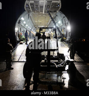 Us-Flieger vom 106 Rettung Flügel der New York Air National Guard Vorbereitung Ausrüstung in eine C-5 M Super Galaxy Flugzeuge aus dem 9. Airlift Squadron zu laden von Dover Air Force Base, Del, Francis S. Gabreski Air National Guard Base, N.Y., Jan. 23, 2018. Das bordpersonal loadmasters schließen Sie ein Kabel an den Motor Dolly in das Erhalten Sie die Rampe hoch und in den Laderaum zu unterstützen. (U.S. Air National Guard Stockfoto