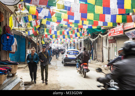 Kathmandu, Nepal - 20. Dezember 2017: Motorrad rauscht durch die Strassen von Thamel, mit Gebetsfahnen geschmückt, im touristischen Zentrum von Kathmandu in Nepa Stockfoto