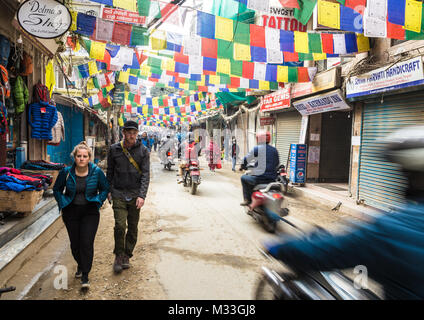 Kathmandu, Nepal - 20. Dezember 2017: Motorrad rauscht durch die Strassen von Thamel, mit Gebetsfahnen geschmückt, im touristischen Zentrum von Kathmandu in Nepa Stockfoto