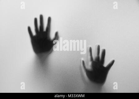 Schatten Hände der Mann hinter Milchglas. Unscharfe hand Abstraktion. Halloween Hintergrund. Schwarz-Weiß-Bild Stockfoto