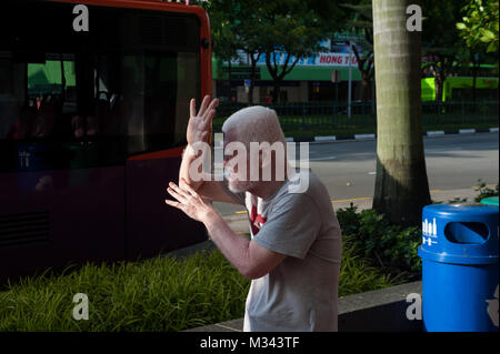 21.12.2017, Singapur, Republik Singapur, Asien - ein Mann wird gesehen, Abschirmung sein Gesicht von der Sonne in Singapur Chinatown. Stockfoto