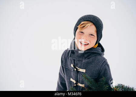 Portrait eines lächelnden jungen stehen im Schnee Stockfoto