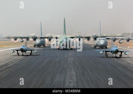 Zwei Bangladesch F-7BG Verteidiger, ein BAF C-130 Hercules und zwei US Luftwaffe C - 130H Herkules Flugzeug vorbereiten von BAF Basis Bangabandhu, Bangladesch, während der Übung zu bewältigen Süden 28. Januar 2015 auszuziehen. Die USA C - 130H erhält die 374th Airlift Wing, Yokota Air base, Japan; BAF F-7BGs 5. Geschwader zugewiesen sind und die BAF C-130 ist 101. fliegen Spezialeinheit an BAF Basis Bangabandhu zugewiesen. Süden zu bewältigen ist eine Pacific Air Forces gesponsert, bilaterale taktische Luftbrücke Übung durchgeführt in Bangladesch, mit einem Fokus auf kooperative Flugbetrieb, Tag und Nacht Low-Level-navigatio Stockfoto