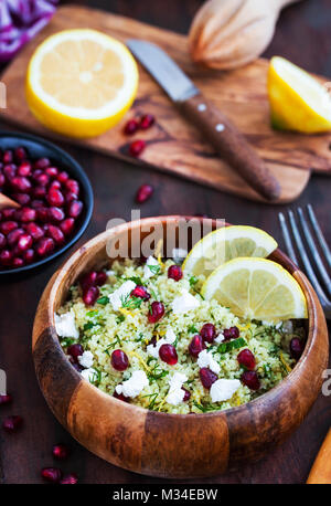 Leckeren, gesunden Cous cous Salat mit Kräutern, Zitronenschale, Fetakäse und Granatapfel Samen Stockfoto