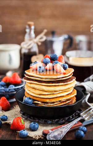 Stapel von frisch zubereiteten Banana Pancakes mit frischen Beeren und Ahornsirup zum Frühstück Stockfoto