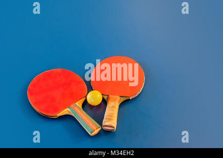 Tischtennis oder Ping pong Schläger und gelben Kugeln auf blauen Tabelle. Sport Konzept. Tischtennis Stockfoto
