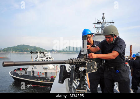 150518-N-BX 824-035 Yokosuka, Japan (18. Mai 2015) Der Gunner Mate Seaman Apprentice Pedro L. Beal (rechts), aus El Paso, Texas, installiert ein.50-Kaliber Maschinengewehr auf dem Vorschiff der Ticonderoga-Klasse geführte-missile Cruiser USS Antietam (CG54) als das Schiff bereitet Yokosuka abzuweichen. Antietam ist auf Patrouille in der Siebten Flotte Bereich der Maßnahmen zur Förderung der Sicherheit und der Stabilität in der Indo-Asia-Pazifik-Region. (U.S. Marine Foto von Mass Communication Specialist 3. Klasse Ricardo R. Guzman / Freigegeben) die japanischen, US-amerikanischen Matrosen für den Einsatz in der Nähe von Kamakura vorbereiten, indem Sie # FIRMA PACOM Stockfoto