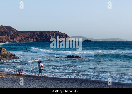 Familie sucht Surfer am Strand von Masua in der Nähe der Pan di Zucchero an der Westküste von Sardinien. Italien. Stockfoto