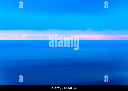 Stilisierte abstrakte Landschaft seascape Sonnenuntergang lange Belichtung mit Wolken unter verschiedenen Schattierungen von Blau, Orange, Gelb und Rot Stockfoto