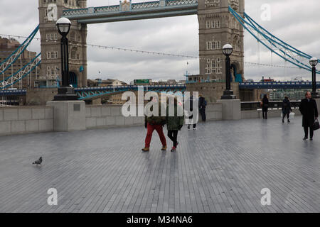 London, Großbritannien. 9 Feb, 2018. Langweilig, kalt und Elend in Queenswalk durch die Themse in London. Menschen warm gegen die Kälte Credit: Keith Larby/Alamy leben Nachrichten Stockfoto