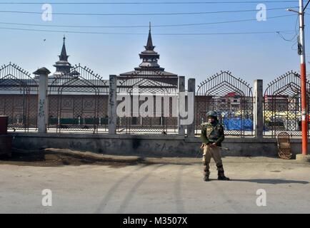 Srinagar, Indien. 9 Feb, 2018. Ein indischer Polizist wacht außerhalb der historischen Moschee während der Ausgangssperre in Srinagar. Behörden auferlegten Beschränkungen in einigen Teilen von Srinagar am Freitag während eines Streiks der Separatisten bezeichnet die Ausführung Jahrestag der Afzal Guru, ein Mann, der verurteilt wurde, Kaschmir und Todesurteil wegen seiner angeblichen Rolle im Jahr 2001 Angriff auf indische Parlament zu markieren. Credit: Saqib Majeed/SOPA/ZUMA Draht/Alamy leben Nachrichten Stockfoto