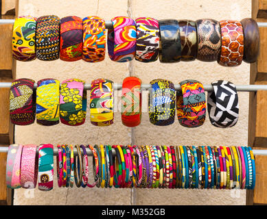 In der Nähe von mehrere bunte, Stoff Bangle Bracelets in einem Rack. In natürliches Licht auf Augenhöhe fotografiert. Stockfoto