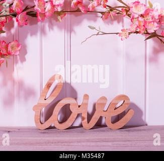 Holzbuchstaben bilden Wort Liebe geschrieben am hölzernen Hintergrund Stockfoto