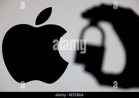 LONDON, UK - 15. MAI 2017: Apple Sicherheitsprobleme. Silhouette einer Hand mit einem Vorhängeschloss vor dem Apple Logo Stockfoto