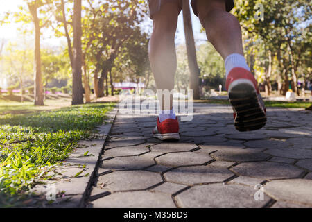 Junge fitness Mann Läufer laufen auf der Straße in Park Stockfoto