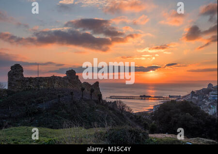 Hastings Castle Wintersonnenuntergang mit dem neuen Pier und Blick über die Bucht nach Beachy Head, East Sussex, Großbritannien Stockfoto