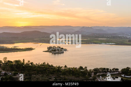 Erhöhten Blick auf Lake Pichola und Aravalli Hills auf einer glühenden Sonnenuntergang Abend in Udaipur, Rajasthan, Indien. Stockfoto