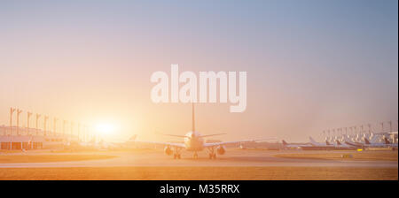 Flugzeug am Terminal Gate startbereit - moderner internationaler Flughafen bei Sonnenaufgang - Konzeptreise um die Welt Stockfoto