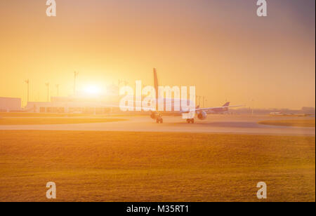 Flugzeug am Terminal Gate startbereit - moderner internationaler Flughafen bei Sonnenaufgang - Konzeptreise um die Welt Stockfoto