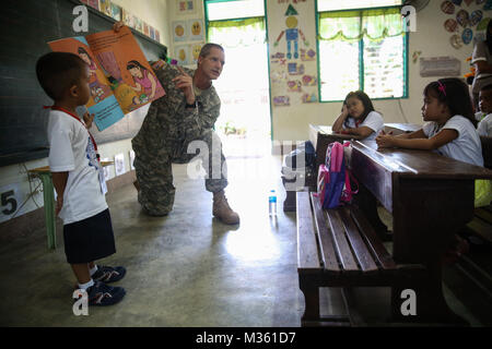 150812-M-GO 800-067 SAN FERNANDO CITY, Philippinen (Aug. 12, 2015) - U.S. Army Oberst David Vetter liest an Studenten Pagudpud Volksschule 12.08.12. Task Force Forager wird in den Philippinen bis 15 August die Bereitstellung medizinischer und technischer Unterstützung. Task Force Forager, schiffte sich an Bord des Military Sealift Command joint high speed Schiff USNS Millinocket (Jhsv 3) ist als zweite Plattform für Pazifische Partnerschaft dienen, geführt von einer expeditionary Befehl Element von 30. der Marine Schiffbau Regiment (30 NCR) von Port Hueneme, Calif. Jetzt in seiner 10. Iteration, Pacific Partn Stockfoto