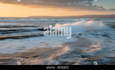 Dramatische mächtige Wellen mit Power on Sea Rock Platten während des Sonnenuntergangs. Akrotiri, Limassol, Zypern Stockfoto