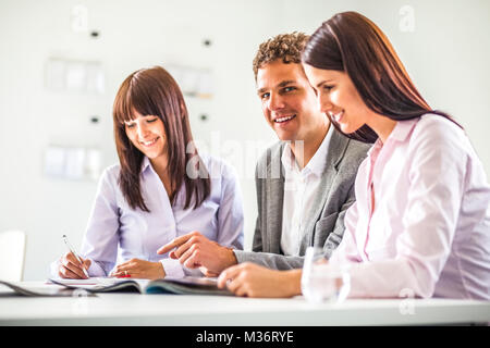Junge Unternehmer in Diskussion mit Kolleginnen in kreative Büro Stockfoto