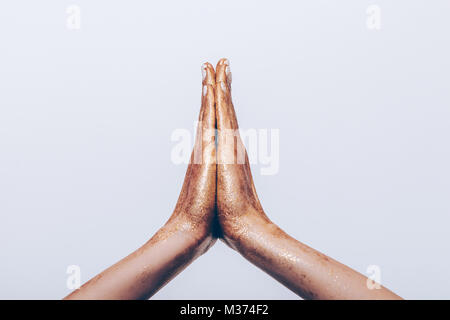 Golden weibliche Hände im Gebet Geste auf weißem Hintergrund close-up Stockfoto