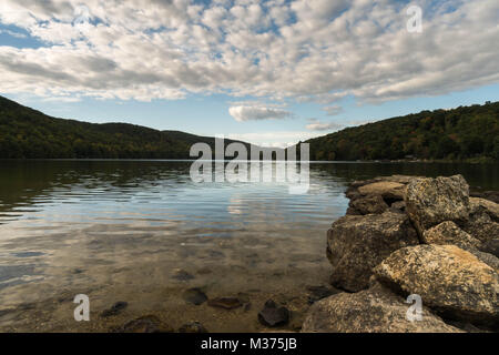 Wunderschöne Mew England Mountain Lake mit Reflexionen und Felsen im Vordergrund Stockfoto