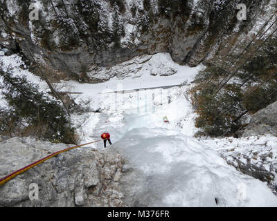 Männliche Eiskletterer auf einem steilen und gefrorenen Wasserfall im Serres di Sottoguda in den italienischen Dolomiten Stockfoto