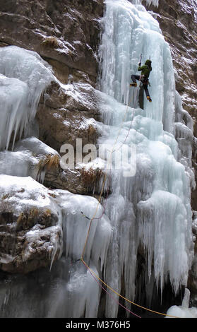 Männliche Eiskletterer auf einem steilen und gefrorenen Wasserfall im Serres di Sottoguda in den italienischen Dolomiten Stockfoto