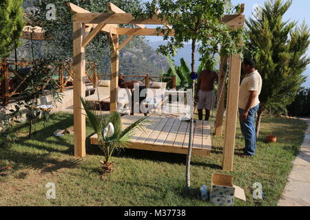 20. Juli 2017, KABAK, Türkei: Türkische Handwerker Bau einer Hollywoodschaukel Pergola in einem Olive Garden an Kabak, Türkei, 20. Juli 2017 Stockfoto