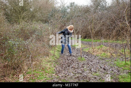 Pulborough Brooks RSPB Nature Reserve in West Sussex UK-Frau Kämpfe durch einen schlammigen Weg zu gehen Stockfoto