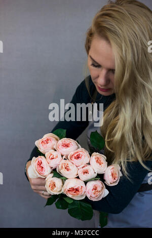 Schöne junge Frau mit großen Blumenstrauß aus Rosen Stockfoto