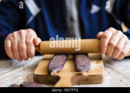 Nahaufnahme des Mannhände, die hausgemachte Würste überrollen zu flach zum Trocknen Stockfoto