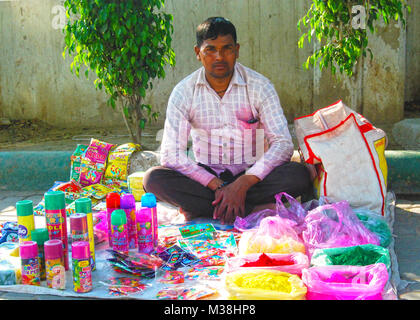 Vor der hinduistischen Frühlingsfest Holi ein Mann verkauf Pulver Farben in einem lokalen Markt von New Delhi, Indien. Stockfoto