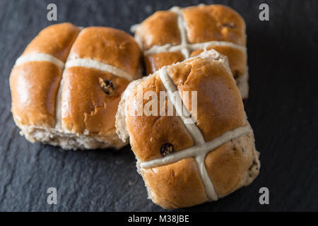 Schöne traditionelle Ostern Hot Cross Buns auf grauem Schiefer Stockfoto