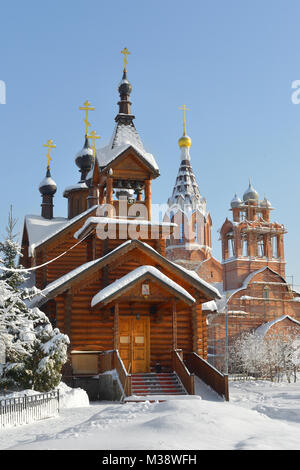 Die hölzerne Kirche der Heiligen Apostel Konstantin und Elena auf dem Hintergrund der Bau der steinernen Kirche der Heiligen Apostel Konstantin und Elena. Moskau, RUS Stockfoto