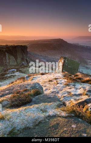 Erstes Licht auf Frost bedeckt Curbar Kante im Winter, in der Nähe von Calver, Nationalpark Peak District, Derbyshire, England, Großbritannien Stockfoto