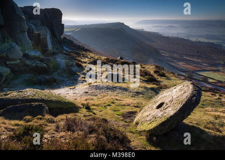 Abgebrochene Mühlstein auf curbar Kante im Winter Nationalpark Peak District, Derbyshire, England, Großbritannien Stockfoto