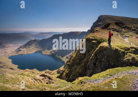 Wanderer, die über Llyn Cau von Craig Cau, Cadair Idris, Snowdonia National Park, North Wales, UK MODEL RELEASED Stockfoto