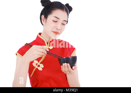 Glückliche Frau tragen chinesische cheongsam Kleid mit Essstäbchen und Schüssel auf weißem Hintergrund Stockfoto